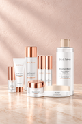 Farmasi Dr. C. Tuna Age Reversist System, eight skincare products with rose gold accents on a warm cream vanity.