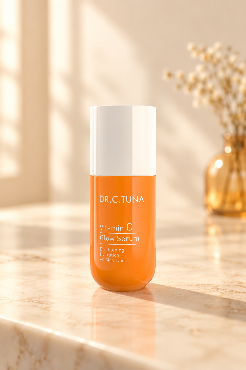 Farmasi Dr. C. Tuna Vitamin C Glow Serum, orange 30 ml bottle on a warm cream vanity in soft morning light.