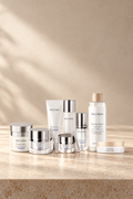Farmasi Dr. C. Tuna Resurface System, eight skincare products in white and silver packaging on a warm cream countertop.