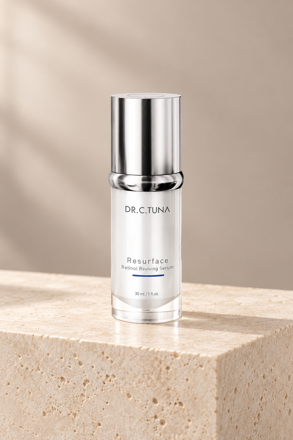 Farmasi Dr. C. Tuna Resurface Retinol Reviving Serum, 30 ml silver bottle on a warm cream stone plinth.